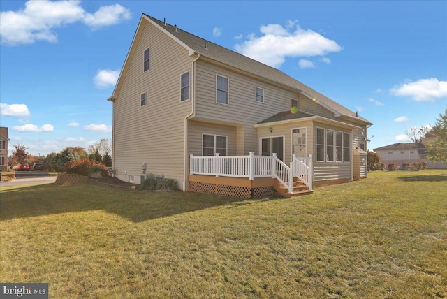 rear view of house with a yard and a wooden deck