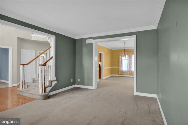 carpeted empty room featuring crown molding and an inviting chandelier