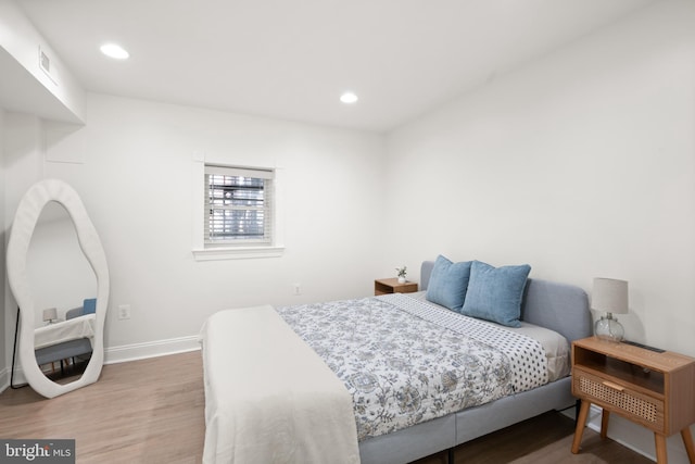 bedroom with recessed lighting, wood finished floors, visible vents, and baseboards