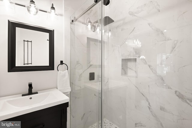 bathroom with vanity and a marble finish shower
