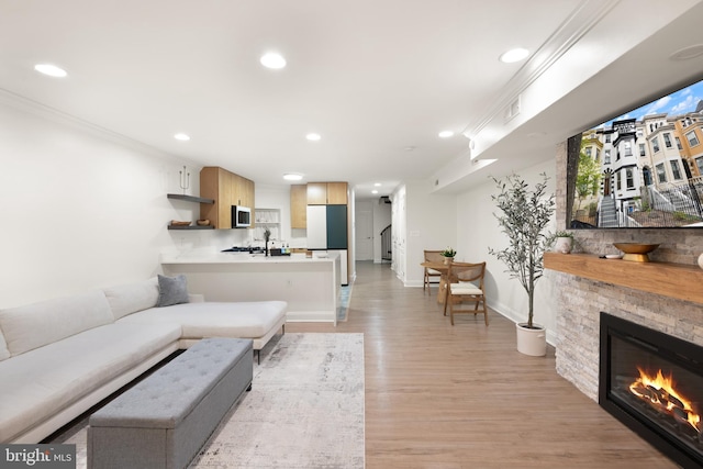 living area featuring recessed lighting, visible vents, light wood-type flooring, baseboards, and a fireplace
