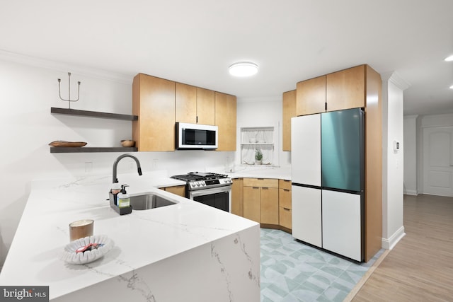 kitchen featuring open shelves, a sink, freestanding refrigerator, stainless steel range with gas cooktop, and white microwave