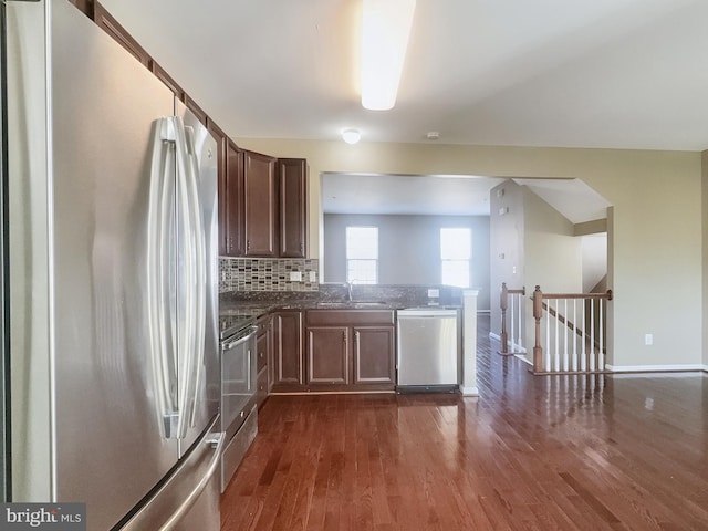 kitchen featuring appliances with stainless steel finishes, sink, dark wood-type flooring, and backsplash