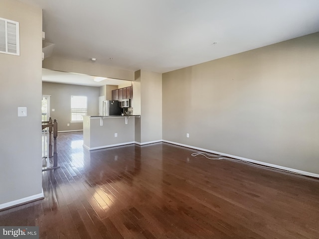 unfurnished living room featuring dark hardwood / wood-style flooring