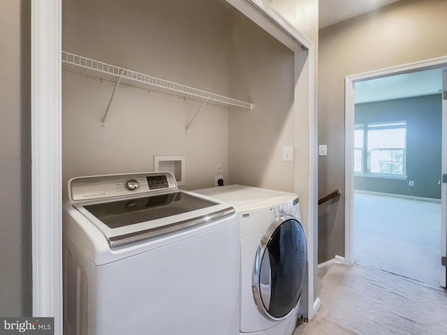 laundry area featuring light carpet and separate washer and dryer