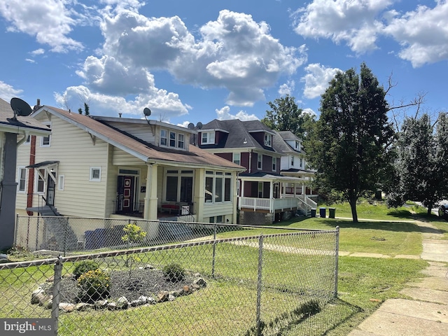 view of front of house featuring a front lawn and fence private yard