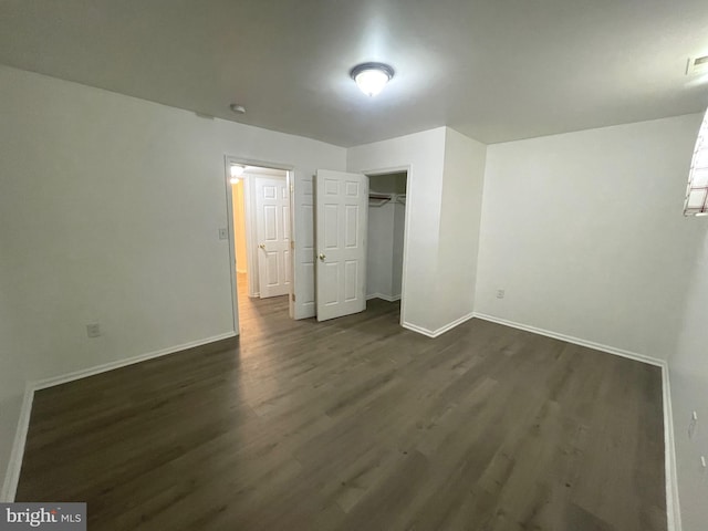 unfurnished bedroom with visible vents, baseboards, a closet, and dark wood-style flooring