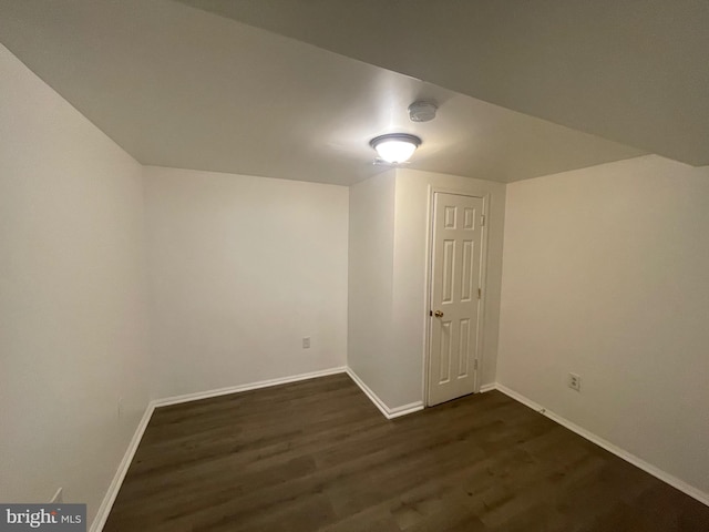 basement featuring dark wood-type flooring and baseboards