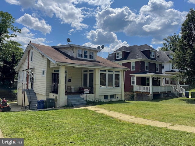 view of front of home featuring a porch, a front lawn, and stairway