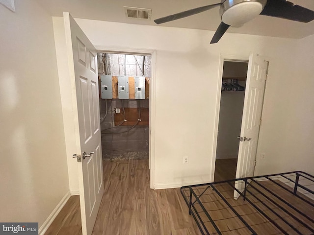 bedroom with baseboards, wood finished floors, visible vents, and a closet
