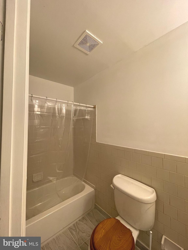 bathroom with toilet, shower / bath combo, tile walls, and tile patterned flooring