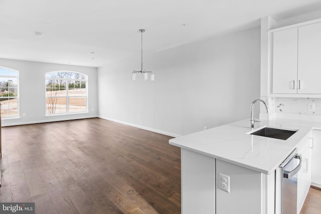 kitchen with light stone counters, wood-type flooring, sink, and white cabinets