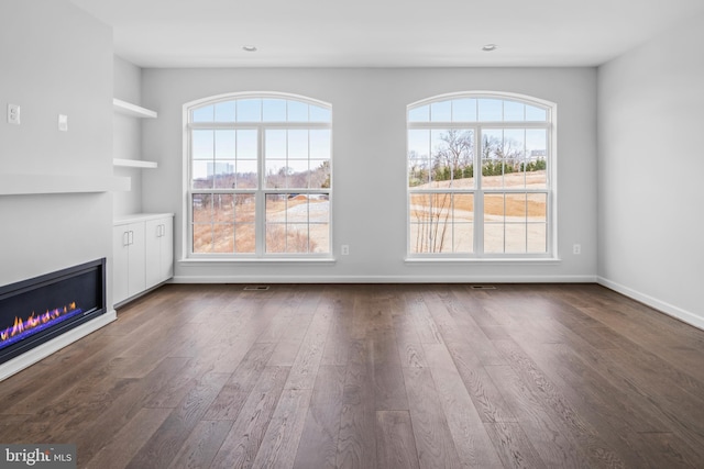 unfurnished living room with dark wood-type flooring