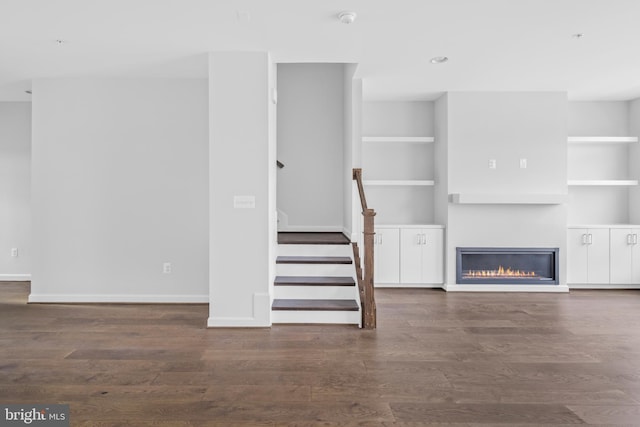 unfurnished living room with dark wood-type flooring and built in features