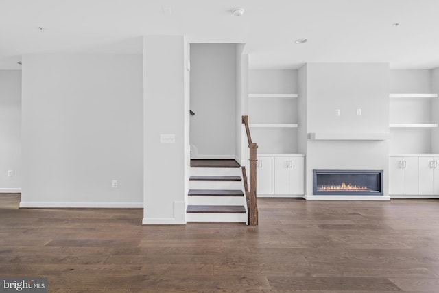 0 Triggerfish Dr, National Harbor, MD 20745 - unfurnished living room featuring wood finished floors, built in shelves, baseboards, a glass covered fireplace, and stairs