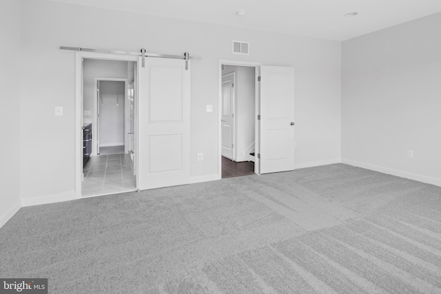 empty room featuring carpet flooring and a barn door