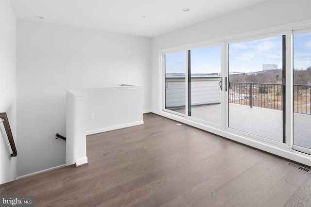 unfurnished living room with dark hardwood / wood-style floors and plenty of natural light