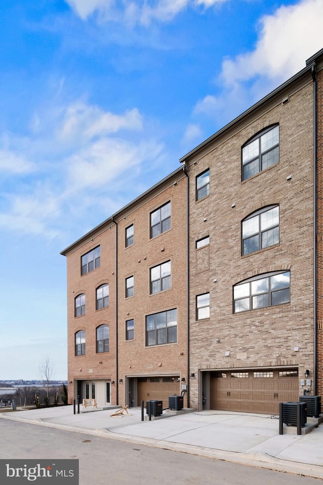 view of property featuring central AC unit and a garage