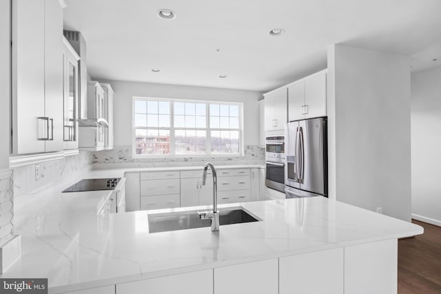 0 Triggerfish Dr, National Harbor, MD 20745 - kitchen featuring stainless steel appliances, a peninsula, a sink, light stone counters, and wall chimney range hood