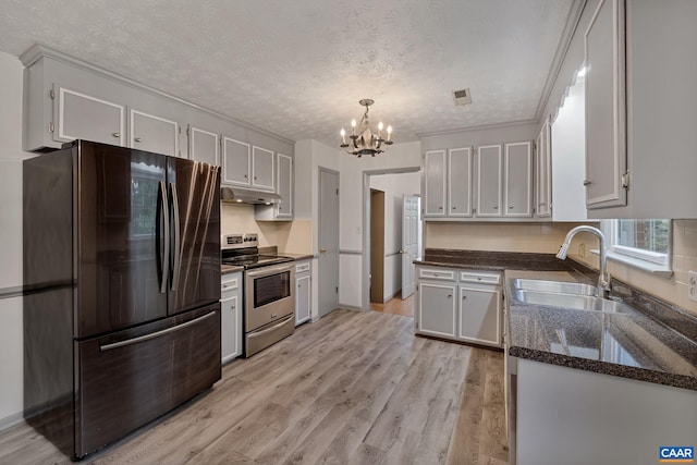 kitchen with white cabinetry, stainless steel appliances, a textured ceiling, and light hardwood / wood-style flooring