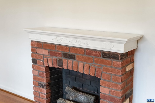 details featuring hardwood / wood-style floors and a brick fireplace