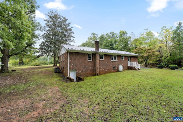 view of side of home featuring a yard and cooling unit