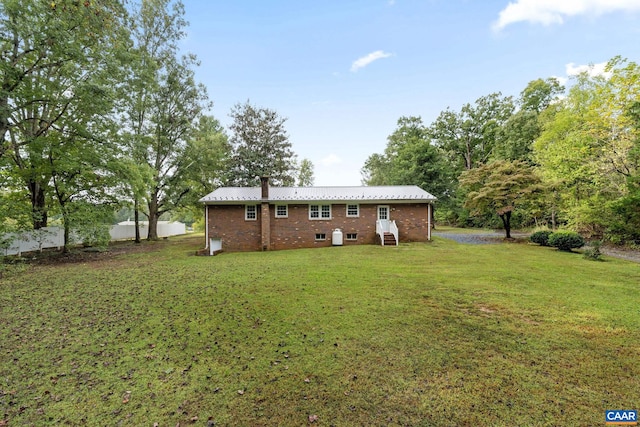 rear view of property featuring a lawn