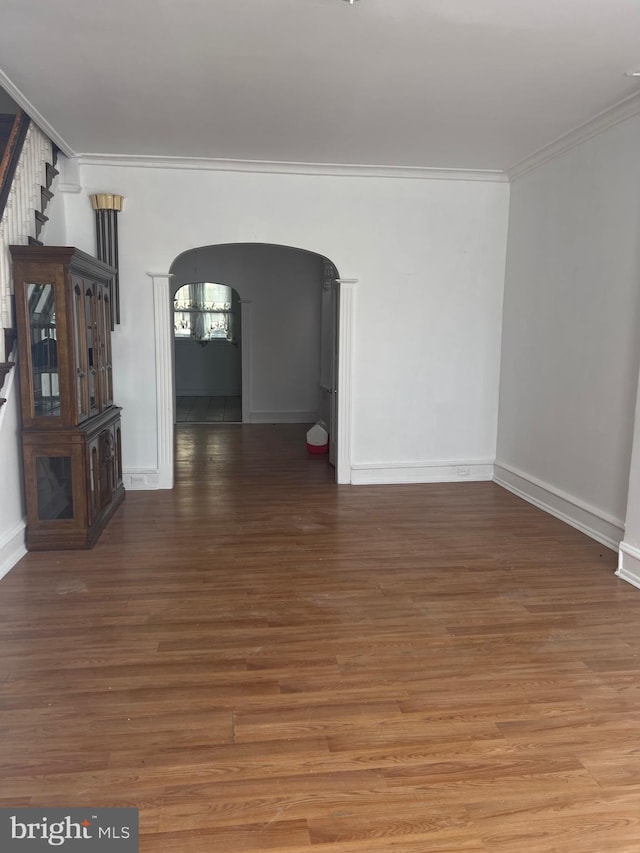 empty room with crown molding and dark hardwood / wood-style flooring