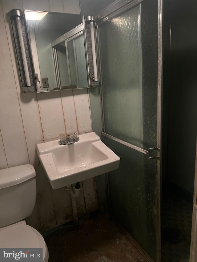 bathroom featuring sink, concrete flooring, toilet, and walk in shower