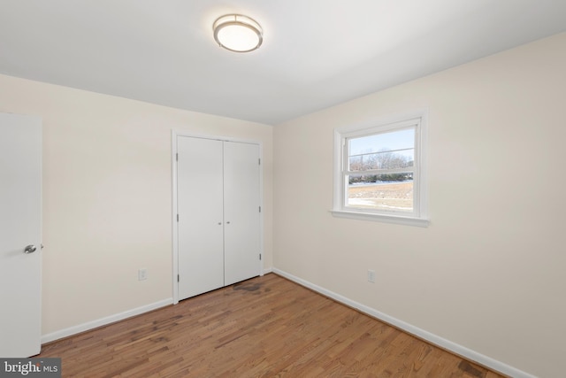 unfurnished bedroom with wood-type flooring and a closet