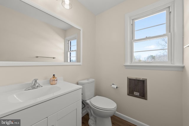 bathroom featuring hardwood / wood-style floors, vanity, heating unit, and toilet