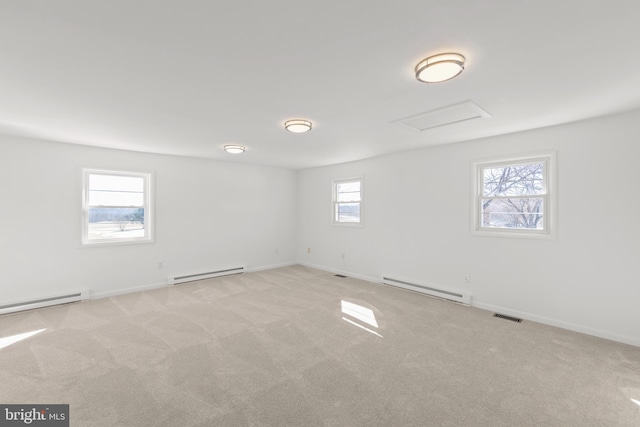 carpeted spare room with a baseboard radiator and a healthy amount of sunlight