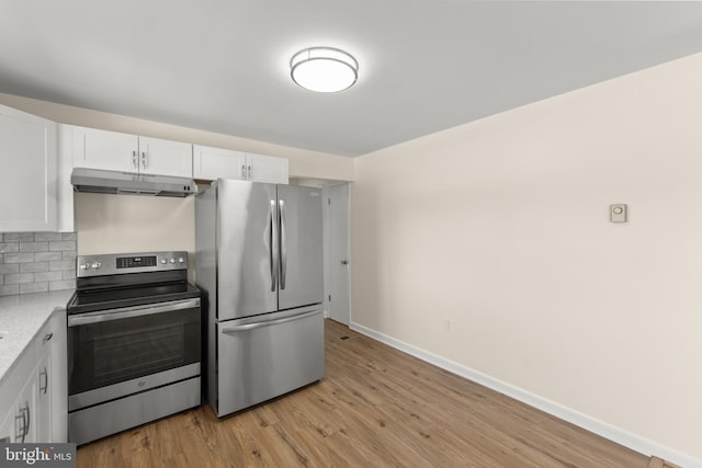 kitchen with light stone counters, appliances with stainless steel finishes, light hardwood / wood-style floors, decorative backsplash, and white cabinets