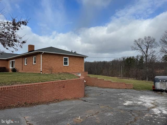 view of side of home with a yard