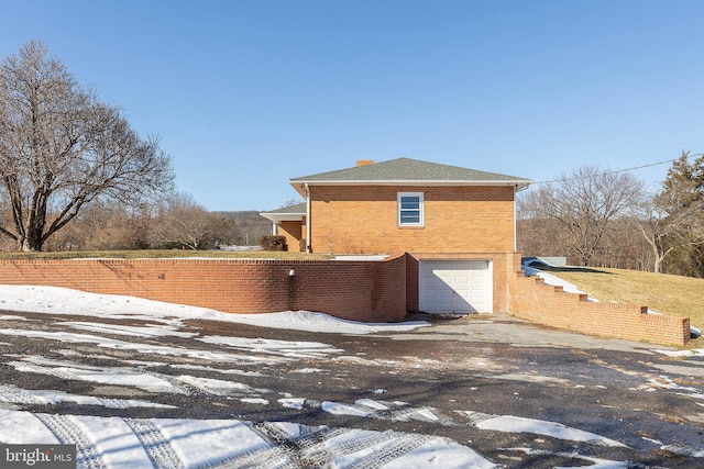 view of snowy exterior with a garage