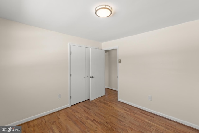 unfurnished bedroom featuring hardwood / wood-style flooring and a closet