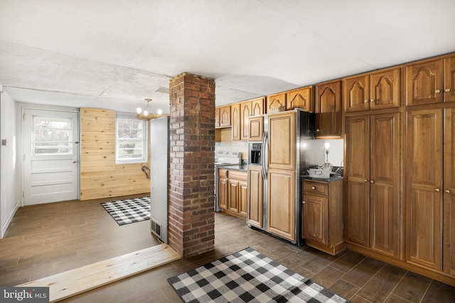 kitchen with wood walls, decorative columns, dark hardwood / wood-style floors, and stainless steel electric range oven