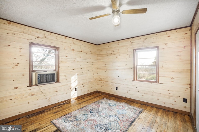 spare room featuring hardwood / wood-style flooring, a wealth of natural light, and wooden walls