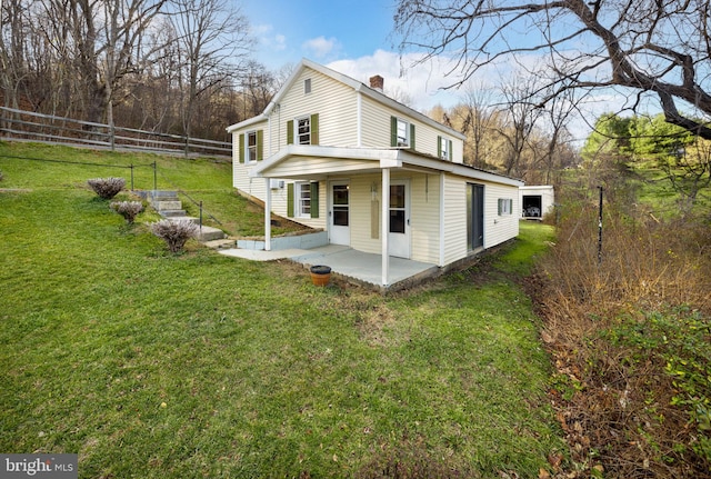 view of side of property featuring fence, a patio area, a lawn, and a chimney