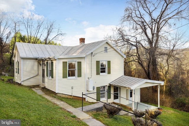 view of front of property with a front lawn and a carport