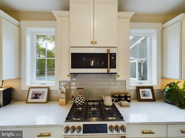 bar with white cabinetry, light stone counters, decorative backsplash, and stainless steel stove