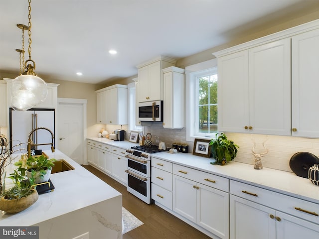 kitchen with white cabinetry, hanging light fixtures, and white appliances