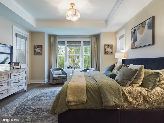 bedroom featuring crown molding, dark hardwood / wood-style floors, and a raised ceiling