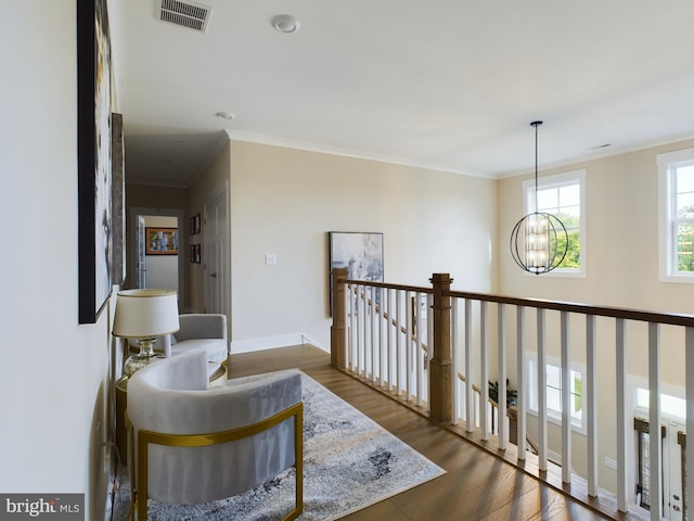 hallway featuring ornamental molding, a chandelier, and dark wood-type flooring