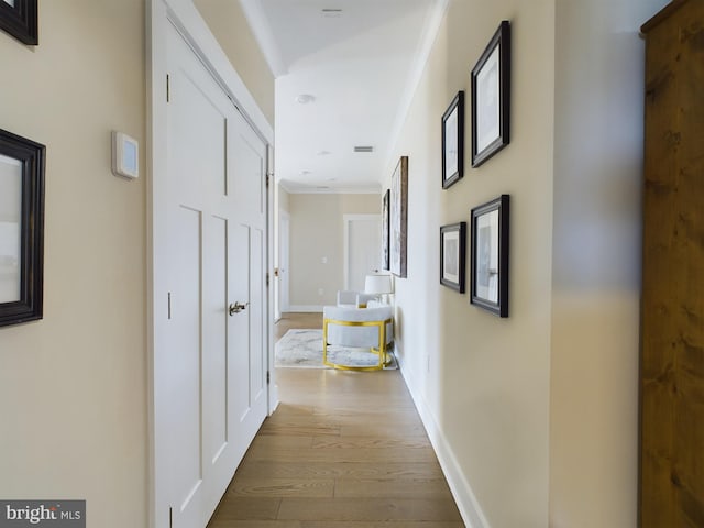 hall with crown molding and light wood-type flooring