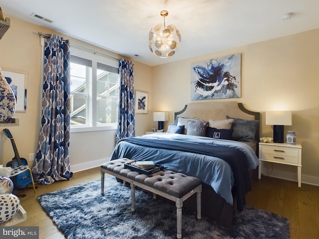 bedroom with an inviting chandelier and wood-type flooring