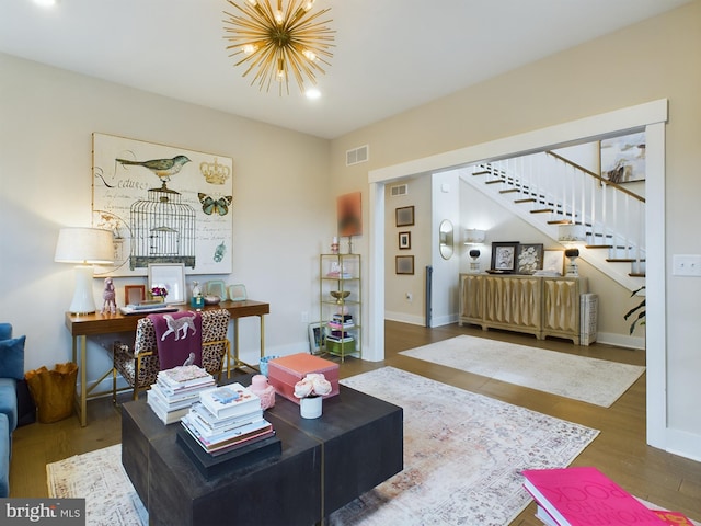 living room with dark hardwood / wood-style flooring and an inviting chandelier