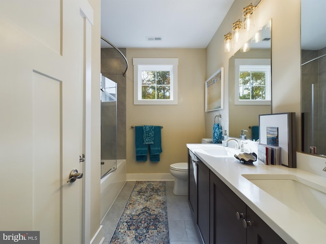 full bathroom with vanity, toilet, tiled shower / bath combo, and tile patterned flooring