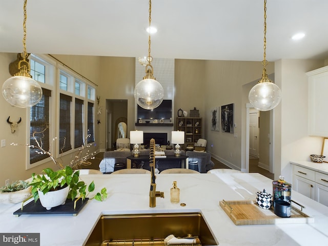 kitchen featuring sink, white cabinetry, and decorative light fixtures