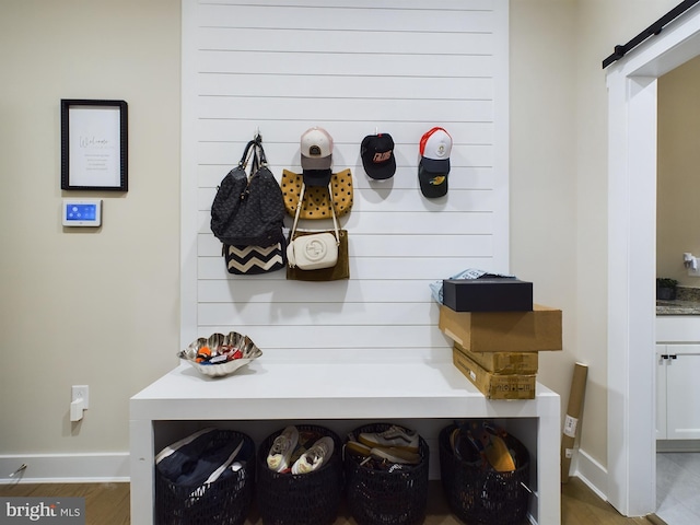 mudroom featuring a barn door and wood-type flooring